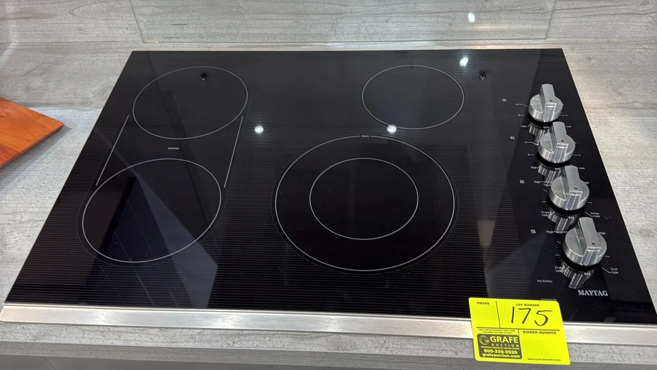 Maytag 4-burner glass top electric cooktop. Features black ceramic glass surface, bridge element, dual-ring element, side rotary control knobs, and st