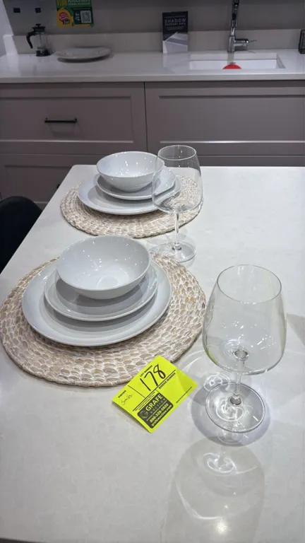Assorted dining smallwares and tableware. Includes dinner plates, salad plates, bowls, woven placemats, wine glasses, champagne flutes, patterned gobl
