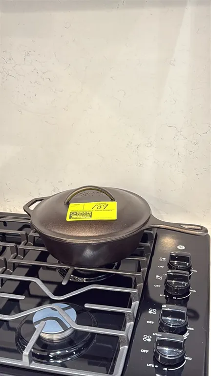 Assorted kitchen smallwares. Includes Lodge cast iron skillet with lid, small cast iron melting pot, glass French press, black wooden serving paddle b
