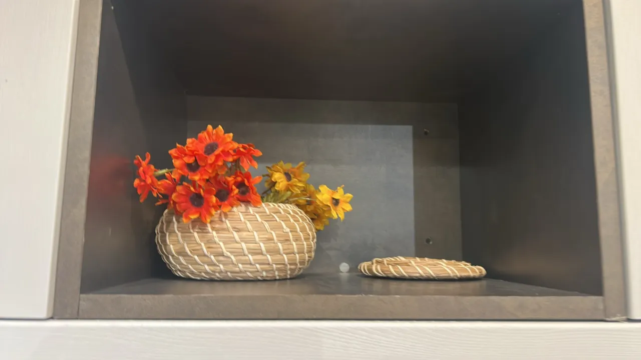 Assorted home decor and kitchenware. Includes (2) accent pillows, knit throw blanket, wire basket, woven basket with artificial flowers, wine glasses,