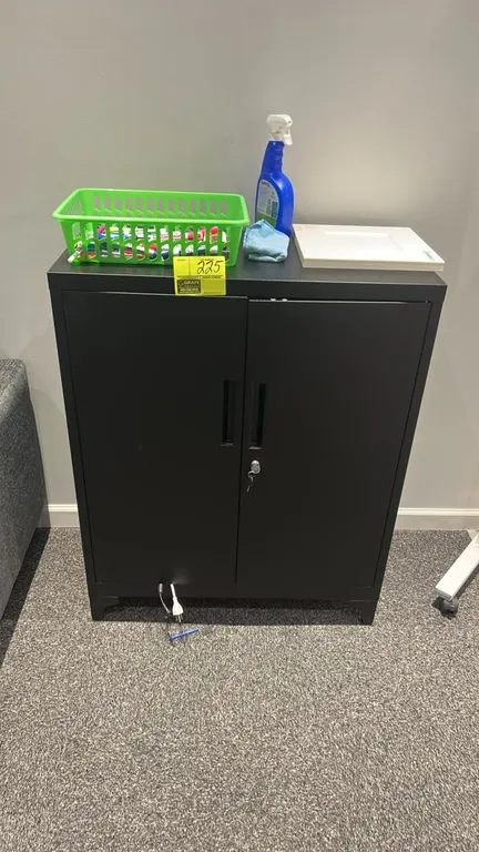 Metal 2-door locking storage cabinet. Features black finish, recessed handles, locking doors with key, and two interior shelves. Contents not included