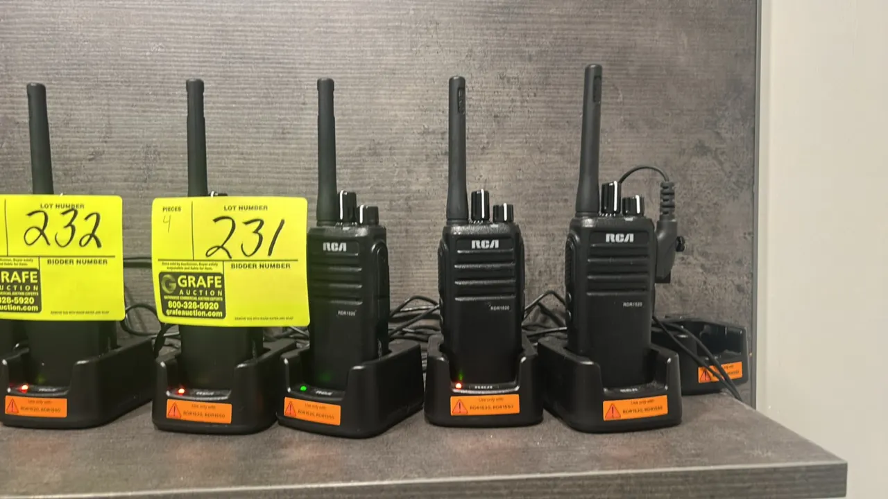 RCA RDR1520 two-way radios. Features top channel and volume control knobs, push-to-talk buttons, and integrated antennas. Includes desktop charging cr
