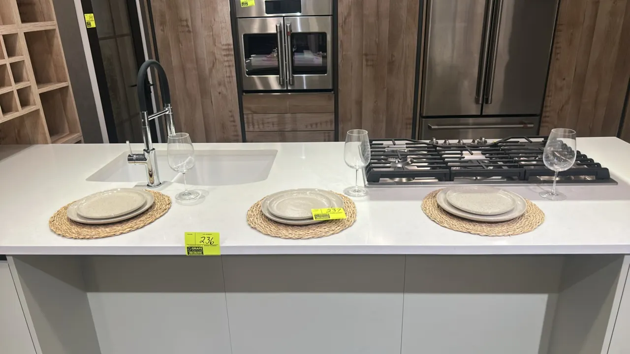 Assorted kitchen smallwares and decor. Includes ceramic dinner plates, woven placemats, glassware, ceramic mixing bowls and pitcher, glass storage jar