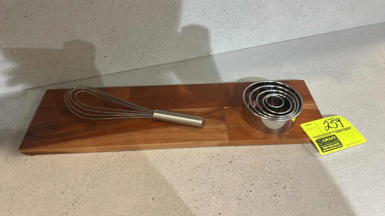 Assorted smallwares and decorative items. Includes wooden serving board, whisk, nested stainless steel round cutters, (4) ceramic plates, and (2) text