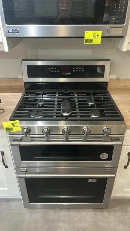 Maytag double oven gas range. Features stainless steel finish, 5-burner gas cooktop with continuous cast iron grates, center oval burner, double oven