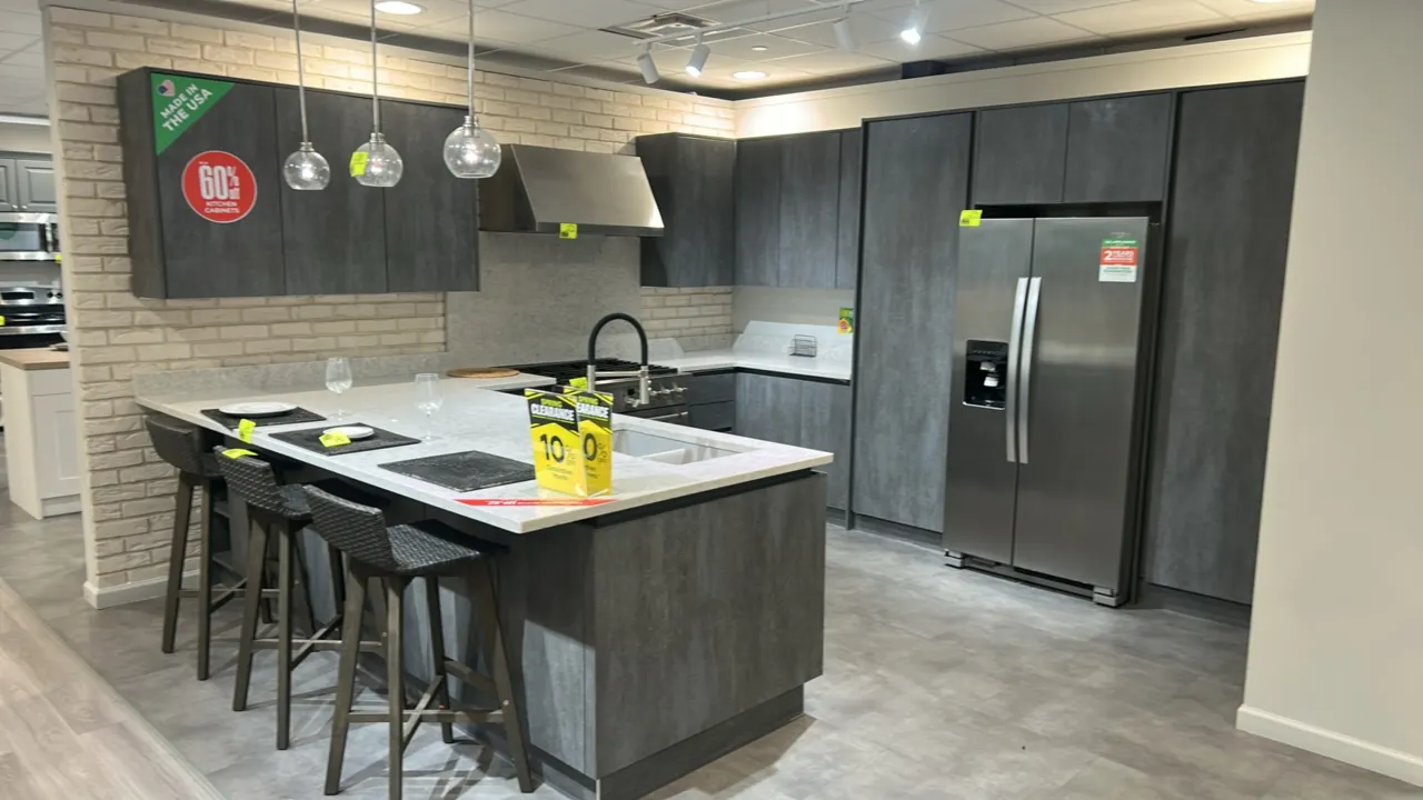 Infinity Plus laminate kitchen cabinet display. Features quartz countertops, Blanco double-basin undermount sink, and stainless steel pull-down faucet