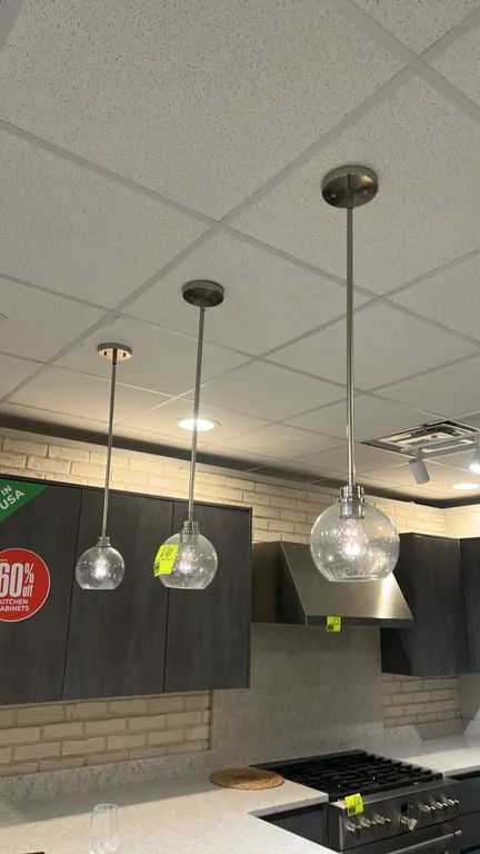 Hanging pendant lights. Features seeded glass globe shades and brushed metal downrods with round ceiling canopies.