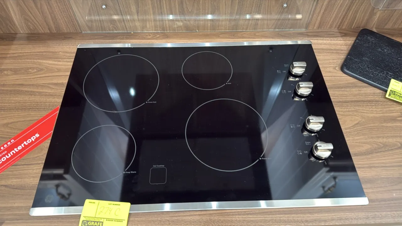 GE JP3030SJ4SS 4-burner glass top electric cooktop. Features black ceramic glass surface with stainless steel trim, Power Boil, Keep Warm, and Melt el