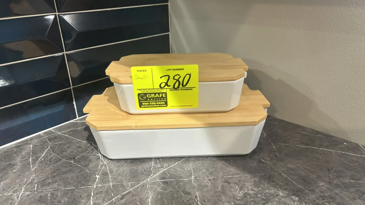 Assorted tableware and kitchen smallwares. Includes (2) ceramic baking dishes with wood lids, (1) glass vase with artificial florals, (1) woven storag
