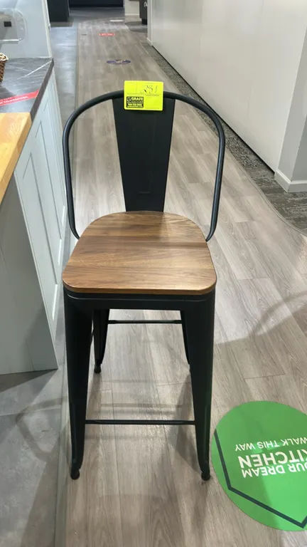 Metal barstool. Features a black metal frame, contoured backrest, wood seat, and integrated footrest rails.