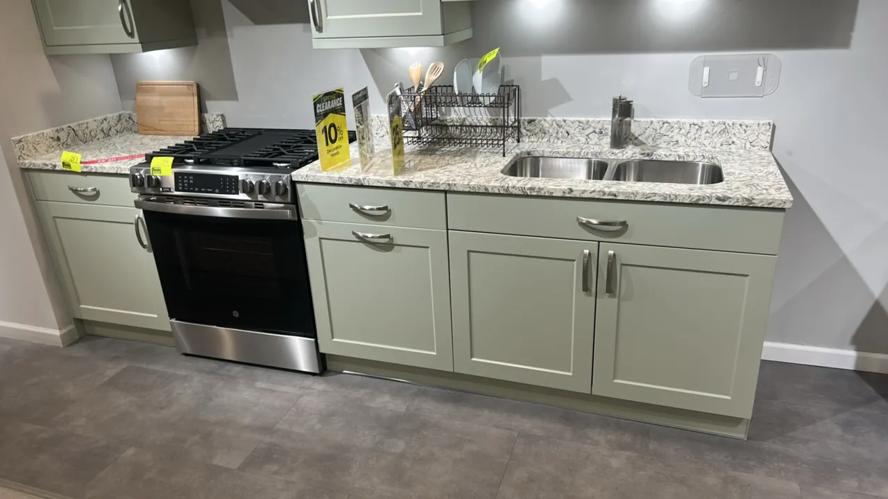Infinity Plus laminate kitchen cabinets. Features quartz countertops, upper wall cabinets, lower base cabinets, stainless steel 2-bowl undermount sink