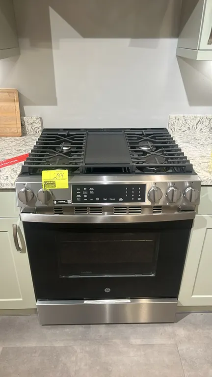 GE GGS600AV1FS 30" slide-in front-control gas range. Features stainless steel finish, 5 burners, continuous cast iron grates, center cast iron griddle