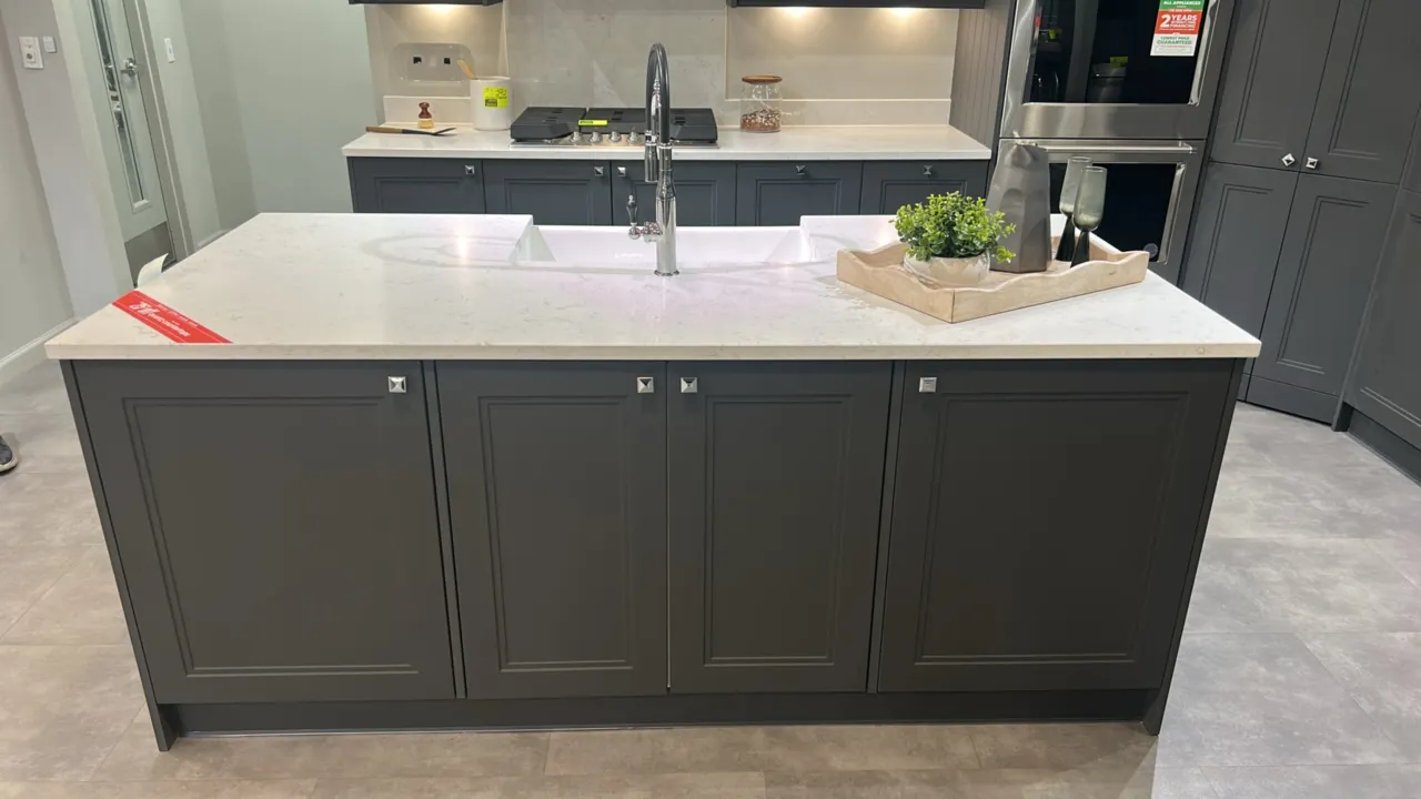 Infinity Plus kitchen island and cabinet set. Features dark gray laminate cabinetry, quartz countertops, apron-front sink insert, and stainless steel