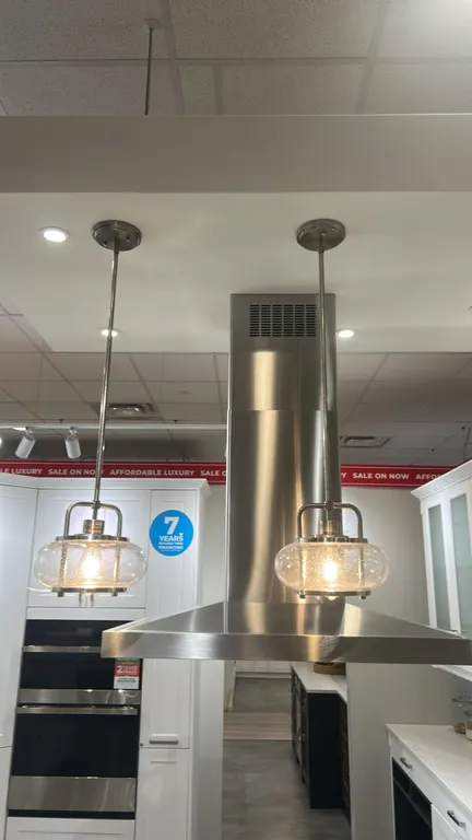 Quoizel Trilogy mini pendant lights. Features clear seeded glass shades, brushed nickel finish metal framework, downrods, and round ceiling canopies.