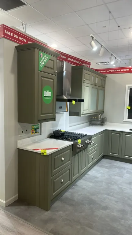 Infinity Plus laminate kitchen cabinet set. Features quartz countertop, Blanco 2-tub undermount sink, sage green cabinetry, upper cabinets with froste