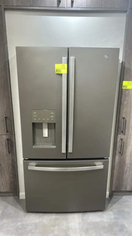 GE GFE26JMMTFES French door refrigerator with bottom freezer drawer. Features exterior water and ice dispenser, adjustable interior glass shelving, cr