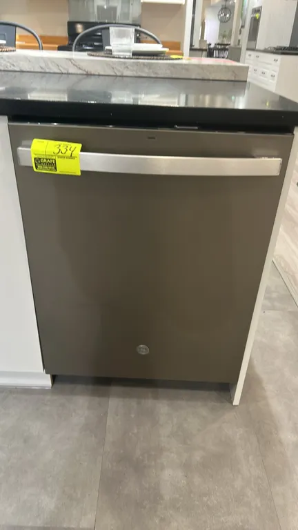 GE Appliances GDT550PMR0ES top control built-in dishwasher. Features bar handle, upper and lower wire dish racks, and silverware basket. S/N: RS717734