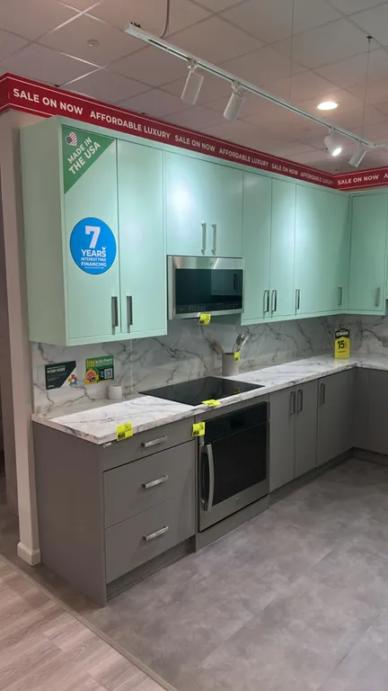 Infinity Plus laminate kitchen cabinets. Features two-tone finish with mint green upper and pantry cabinets, gray base cabinets, marble-look solid sur