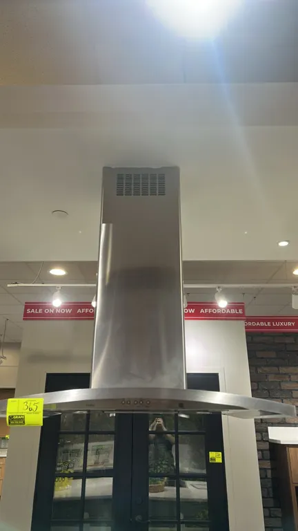 GE Profile PV977N4SS 36" stainless steel island-mount chimney hood. Features electronic push-button controls, telescopic chimney flue, and integrated