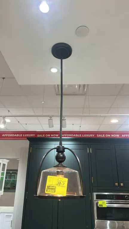 Ceiling hanging circular pendant lights. Features dark bronze-tone metal frames, clear glass cloche-style shades, arched support arms, and downrods wi