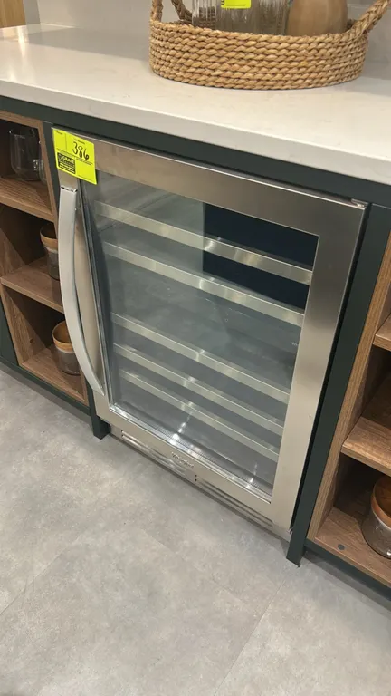 Whirlpool WUW55X24HS01 self-contained undercounter wine cellar. Features a stainless steel framed glass door, slide-out wine racks with stainless fron