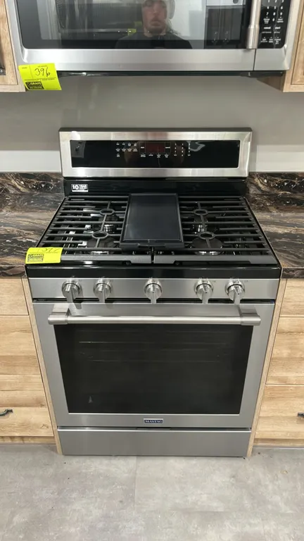 Maytag MGR8800FZ1 5-burner gas range. Features stainless steel finish, continuous cast iron grates, center griddle plate, convection oven, and 3 inter