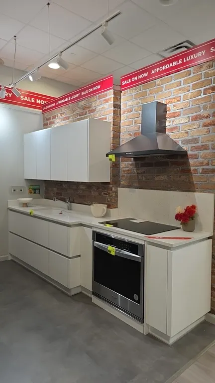 Infinity Plus kitchen cabinet set. Includes upper and lower flat-panel cabinetry, solid surface countertops, and integrated double-bowl sink with sing