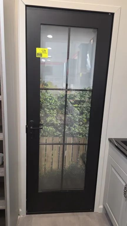 Metal 6-glass panel door. Features a dark gray finish, clear glass panels, and matching lever handle and deadbolt. 29"W x 80"H. Note: Background items