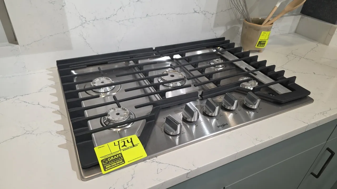 Whirlpool WCG77US0HS00 5-burner natural gas built-in cooktop. Features stainless steel finish, continuous cast iron grates, and front control knobs. 3