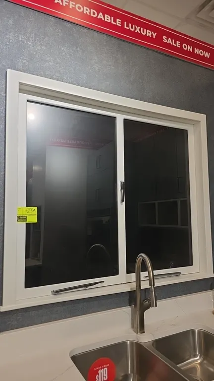 Casement display windows. Features white frame and casing, dual glass panels, and chrome hardware. Note: Countertop, sink, faucet, and surrounding cab