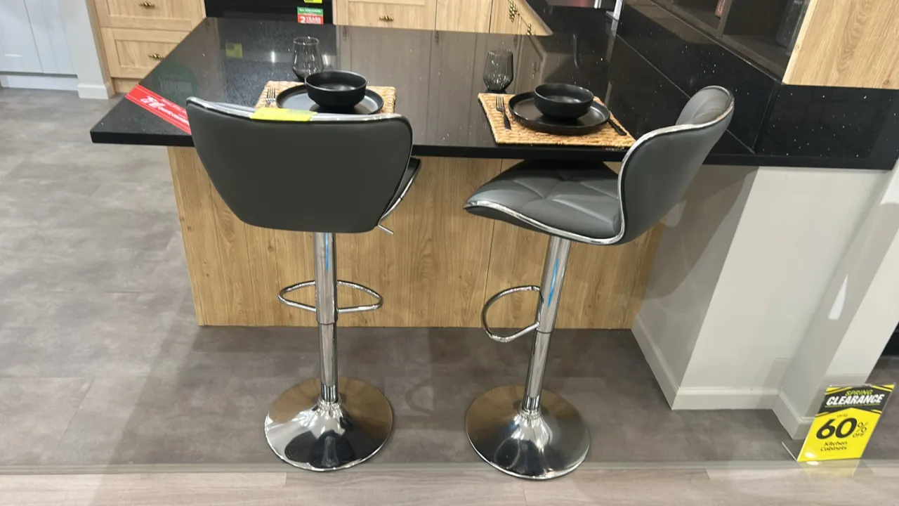 Cushioned barstool. Features gray geometric-stitched upholstery, chrome-finish trim, pedestal base with integrated footrest, and pneumatic height adju