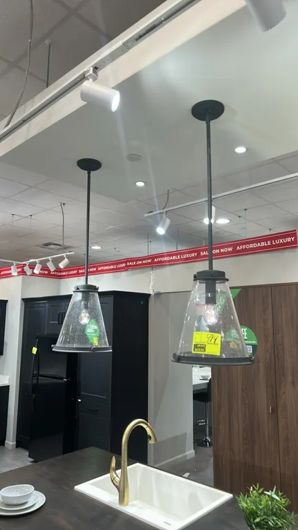 Robert Stevenson Lighting Wesley ceiling lights. Features dark-finish metal frames, clear seedy glass cone shades, and rod suspension with round ceili