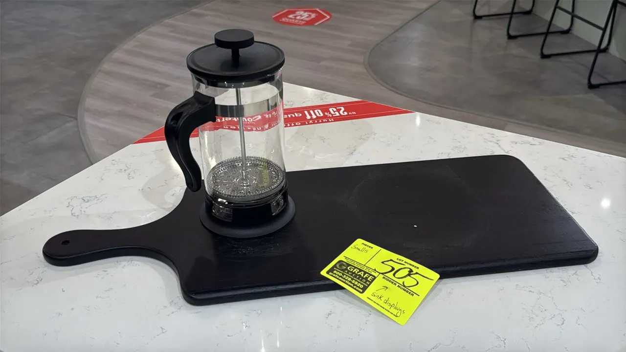 Assorted kitchen smallwares and display decor. Includes black wooden paddle serving board, glass French press coffee maker, clear glass storage jar wi