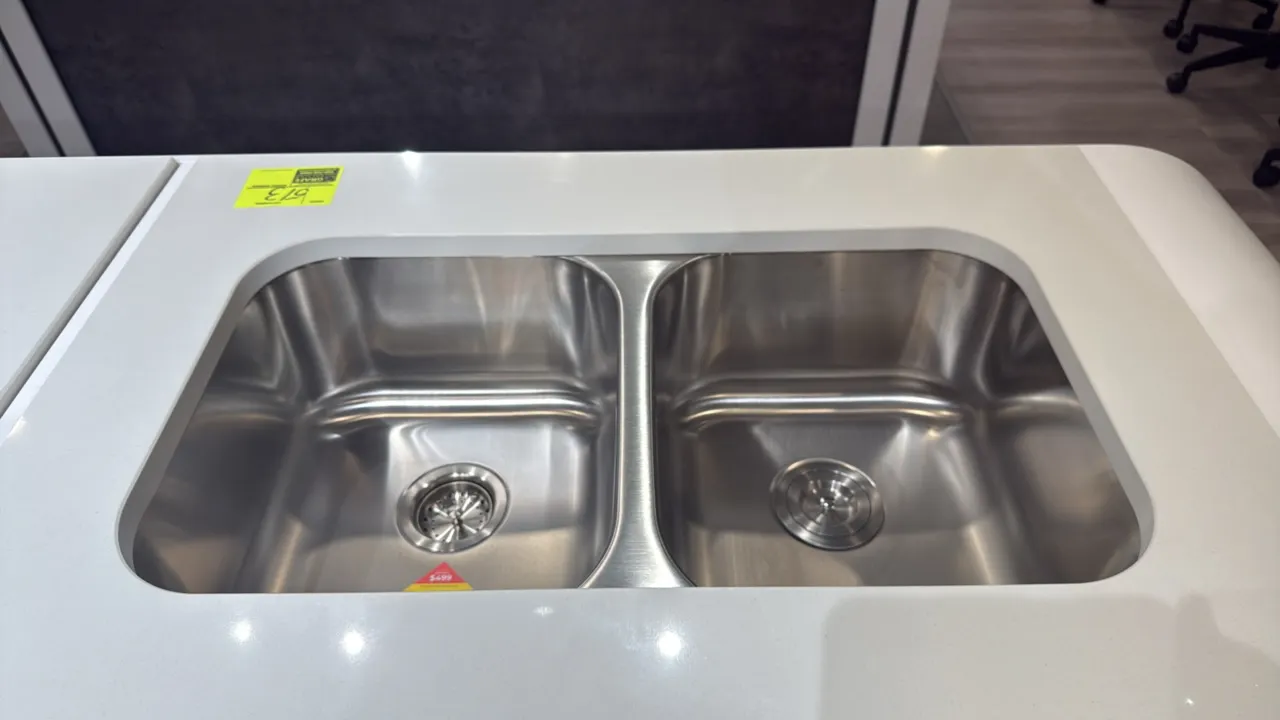 Stainless steel 2-bowl undermount sink. Model: SI.UKI.SS.02.001. Features a 50/50 double basin design. Includes drain basket strainers. 33"L. Note: Co