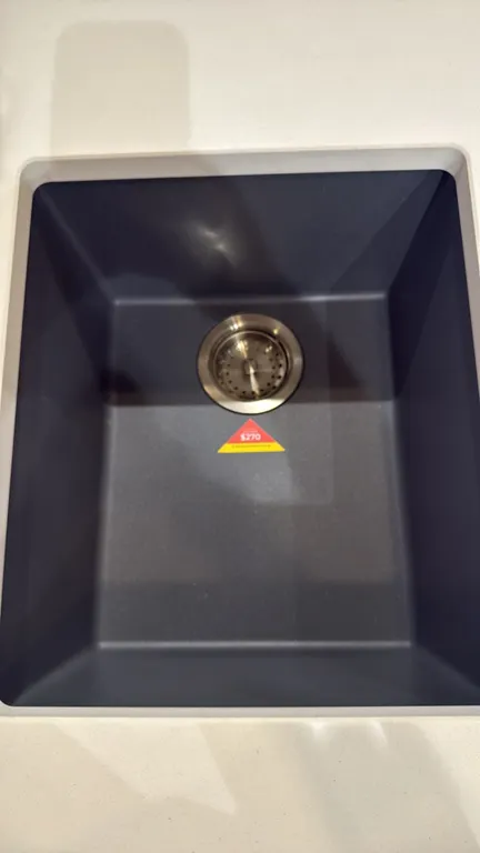 Single-bowl composite sink. Features a concrete gray finish, dual-mount installation design, and stainless steel basket strainer drain assembly. 16".
