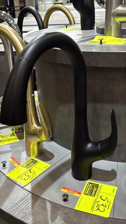 Bocchi Yukon pull-down faucet. Features a matte black finish, single-lever handle, and pull-down spray head. Note: Display stand and adjacent faucets