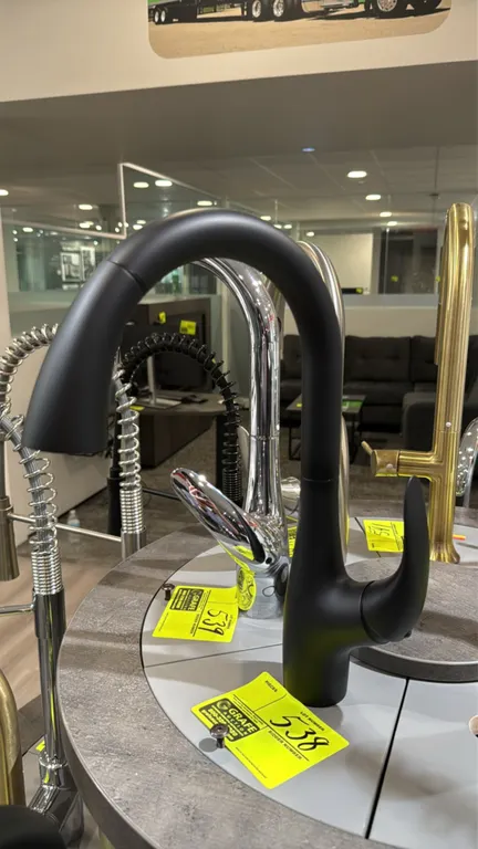 Bocchi pull-down faucet. Features a matte black finish, high-arc spout, single-lever handle, and pull-down spray head. Note: Display base and surround