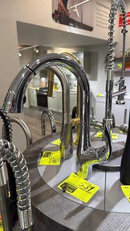 Bocchi pull-down kitchen faucet. Features a polished chrome finish, high-arc spout, single lever handle, and pull-down spray head. Display stand and a