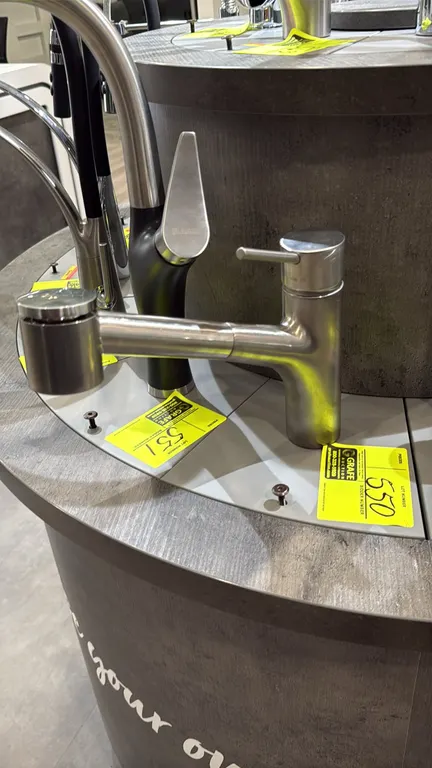 Canadian pull-down kitchen faucet. Features stainless steel finish, single lever handle, and pull-out spray head. Display base not included.