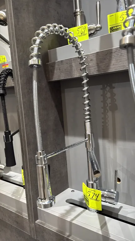 Commercial-style spring pull-down kitchen faucet. Features a polished chrome finish, single-lever handle, high-arc spring spout with pull-down spray h