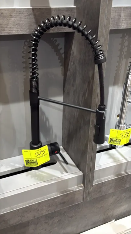 Pull-down spring kitchen faucet. Features matte black finish, single-lever handle control, high-arc open coil spring spout, and pull-down sprayer head