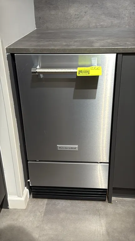KitchenAid KUID308HPS01 self-contained undercounter ice maker. Features stainless steel finish, tubular towel-bar handle, internal storage bin, and co