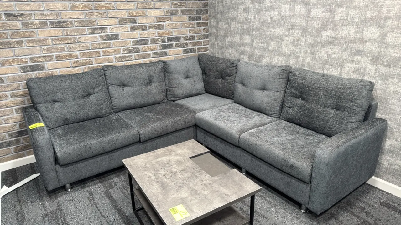 L-shaped sectional couch. Features gray textured fabric upholstery, tufted back cushions, and chrome-finished legs. 87" x 59". Coffee table not includ