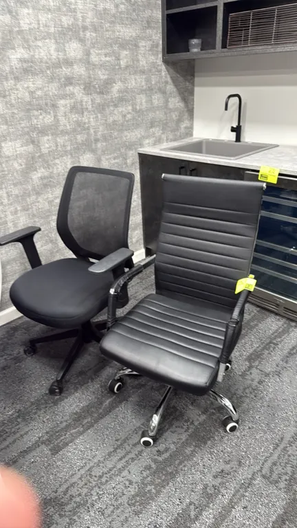 Office chairs. Includes (1) black ribbed high-back chair with chrome base and (1) black mesh-back task chair with upholstered seat and adjustable arms