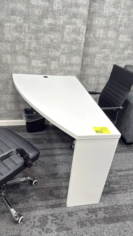 Laminate wall-mounted desk. Features white laminate construction, an angled work surface, and an integrated cable management grommet. 51"L. Supported
