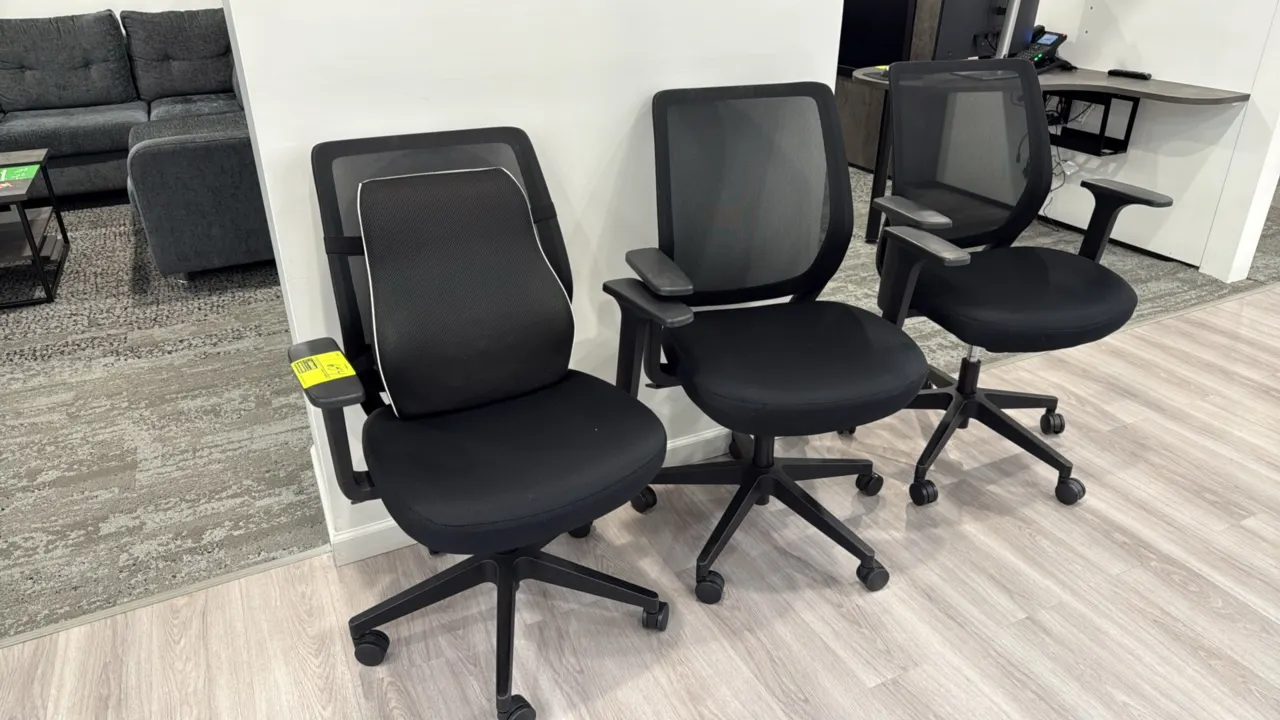 Rolling mesh-back office chairs. Features breathable black mesh backrests, upholstered cushioned fabric seats, armrests, and pneumatic seat-height adj
