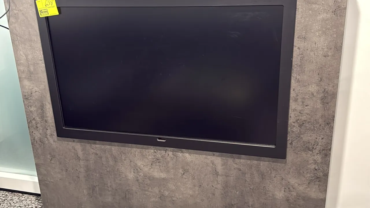 Samsung 50" flat screen color display monitor. Features a black bezel. Mounting panel in background not included.