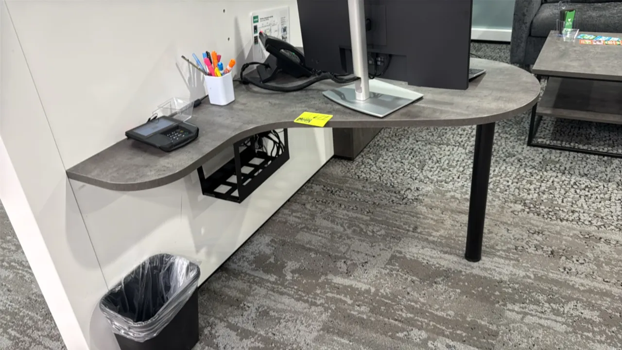Laminate wall-mounted desks. Features stone-look laminate work surfaces and under-desk cable management trays. 42". Supported by single black metal su