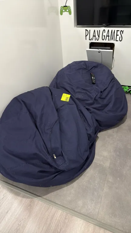 Bean bag chairs. Features navy blue fabric covers and zippered closures. Remote control, electronics, and surrounding items not included.