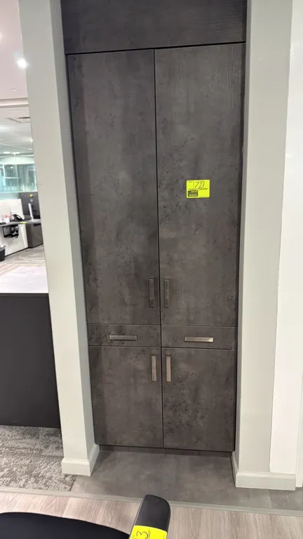Laminate storage cabinet. Features a dark textured finish, upper double doors, two center drawers, and lower double doors with silver-tone bar pulls.